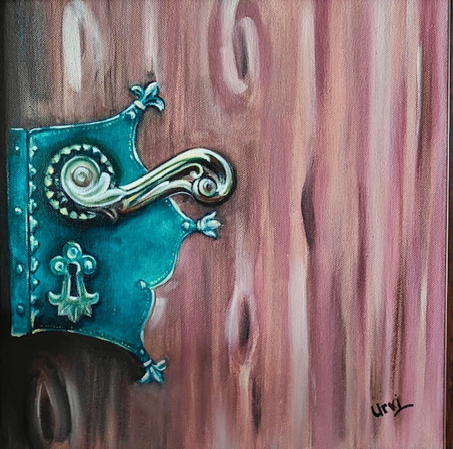 A decorative turquoise handle against a rose-coloured door.