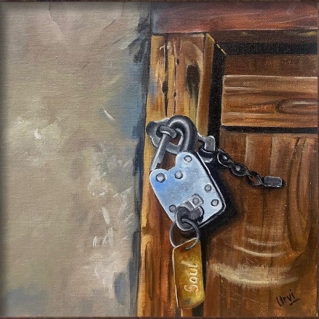A silver padlock and key against a wooden door.